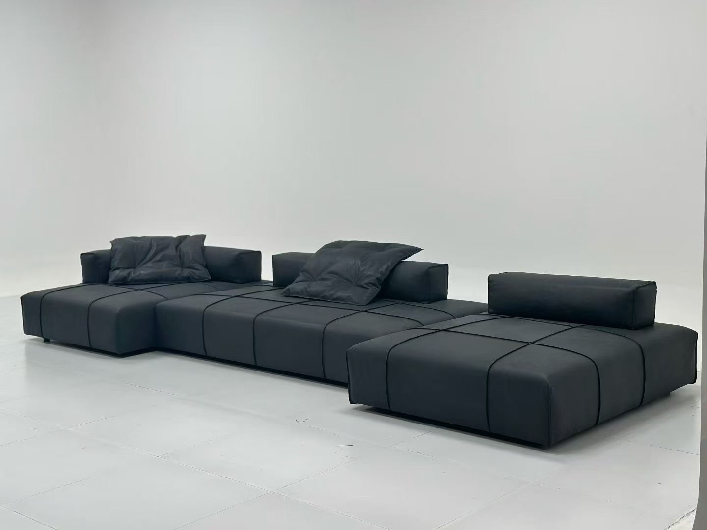 Supplier-provided image of a dark low-profile sectional sofa